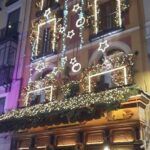Ancien bâtiment à Madrid décoré de nombreuses lumières et guirlandes de Noël brillantes.