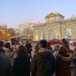 La visite comprend un arrêt devant la Puerta de Alcalá, illuminée pour Noël.