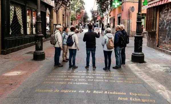 Grupo de turistas sobre las letras en los adoquines del barrio de las letras en Madrid.