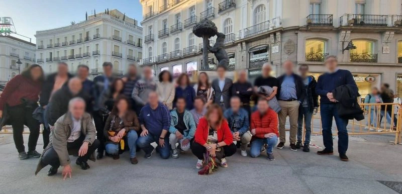Grand groupe en visite guidée à la Puerta del Sol, devant la statue de l'Ours et l'Arbousier, Madrid